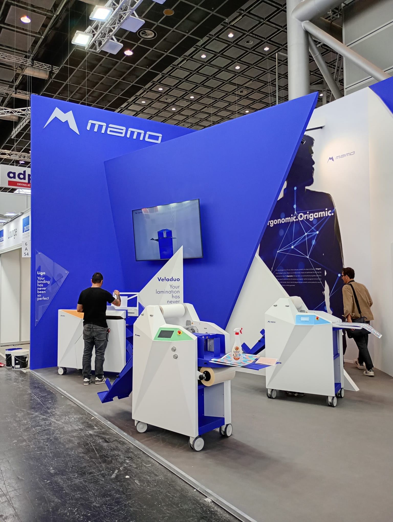 Blue and white exhibition stand with machinery on display