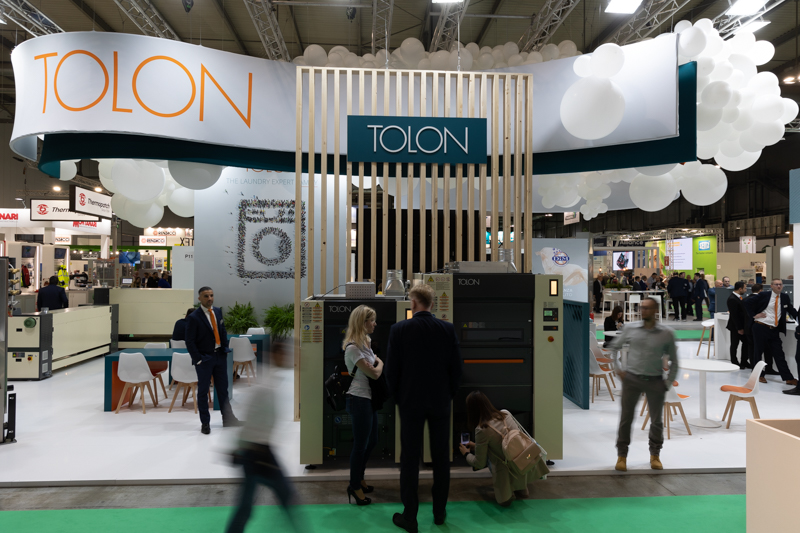Stand fieristico con portale in listelli di legno e sfere bianche sospese