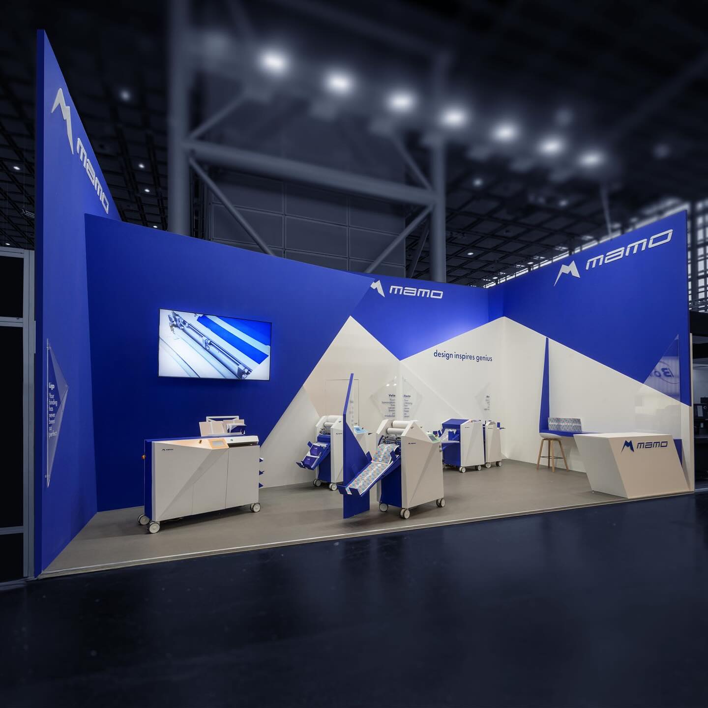 Vista completa dello stand MAMO con pareti blu e bianche